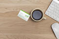 Bureau met koffie, toetsenbord en visitekaartje van EVD Personal Finance